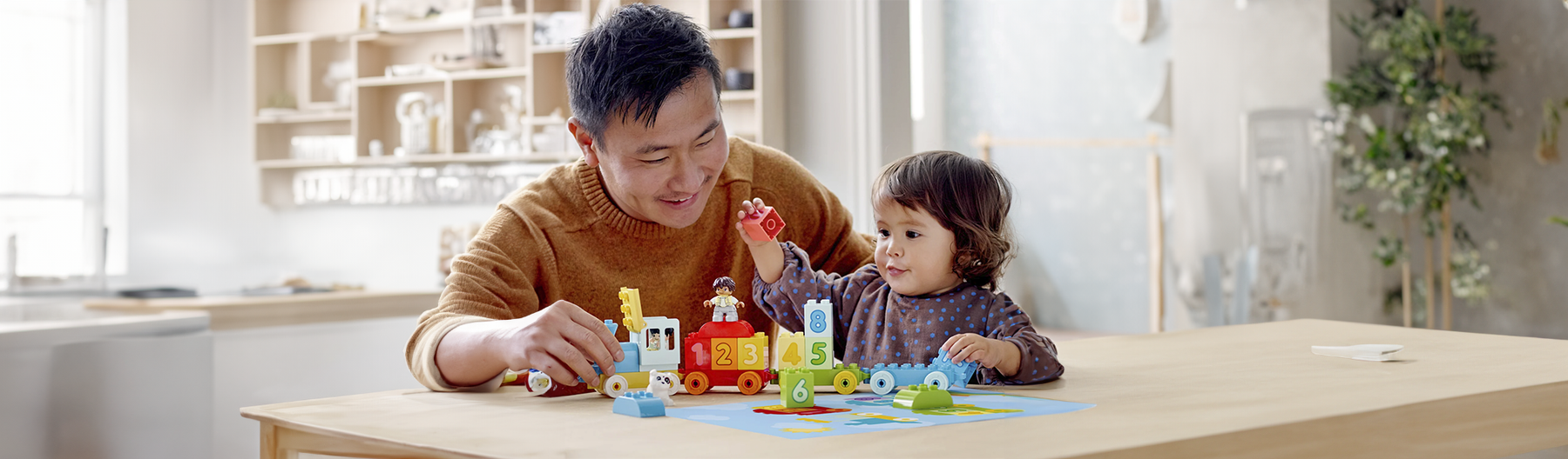 Padre e hijo jugando con LEGO en casa.